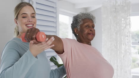 Fisioterapeuta-Femenina-Caucásica-Con-Mujer-Mayor-Haciendo-Ejercicio,-Espacio-Para-Copiar,-Cámara-Lenta