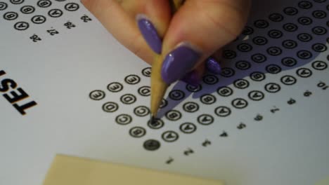 female student checking test answer boxes with a pencil