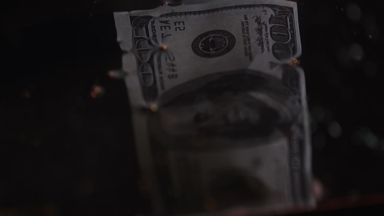 一百美元的钞票浸在油中