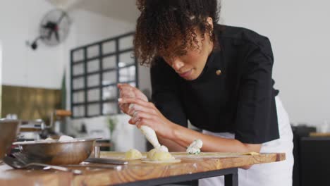 Diverse-group-of-chefs-preparing-dishes-and-smiling-in-a-kitchen