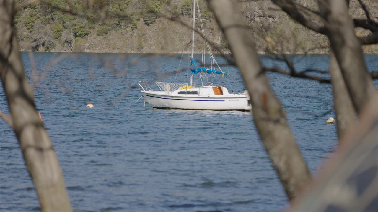 Sailboat anchored in Lácar Lake during summer sports activities in Argentine Patagonia. Nauquén.