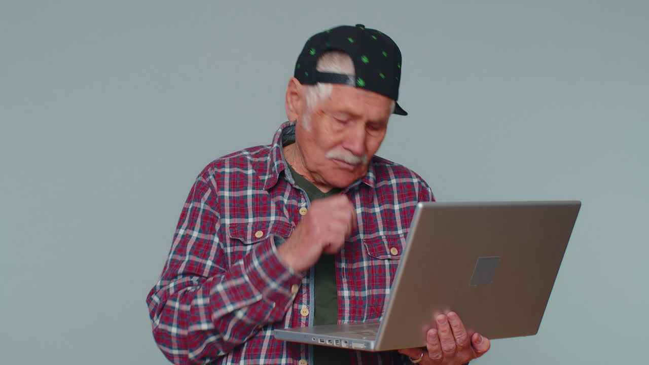 un anciano feliz escribiendo en una computadora portátil, trabajando en un proyecto, disfrutando de los resultados, ganando la lotería.