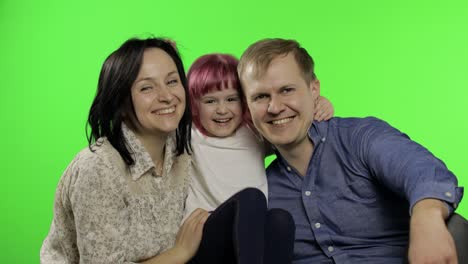 familia feliz de tres padre, madre e hija. abrazar, jugar, reír, sonreír