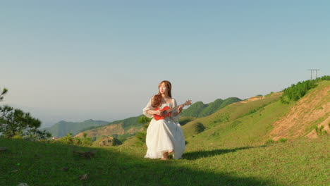 woman playing ukulele on a hilltop
