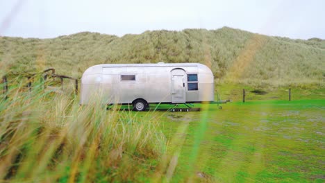 trailer parked on a green meadow. camper. caravan. motor home. recreational vehicle. rv.