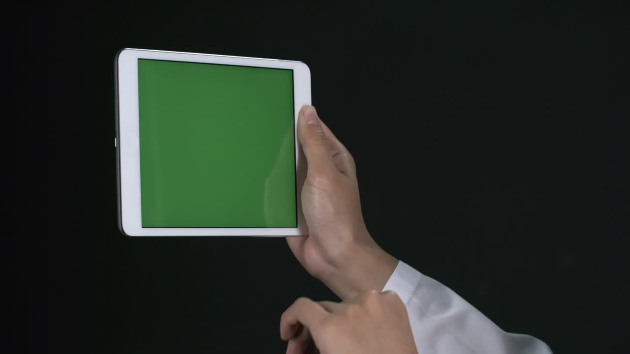 녹색 화면으로 태블릿에 스크롤하는 여성 손