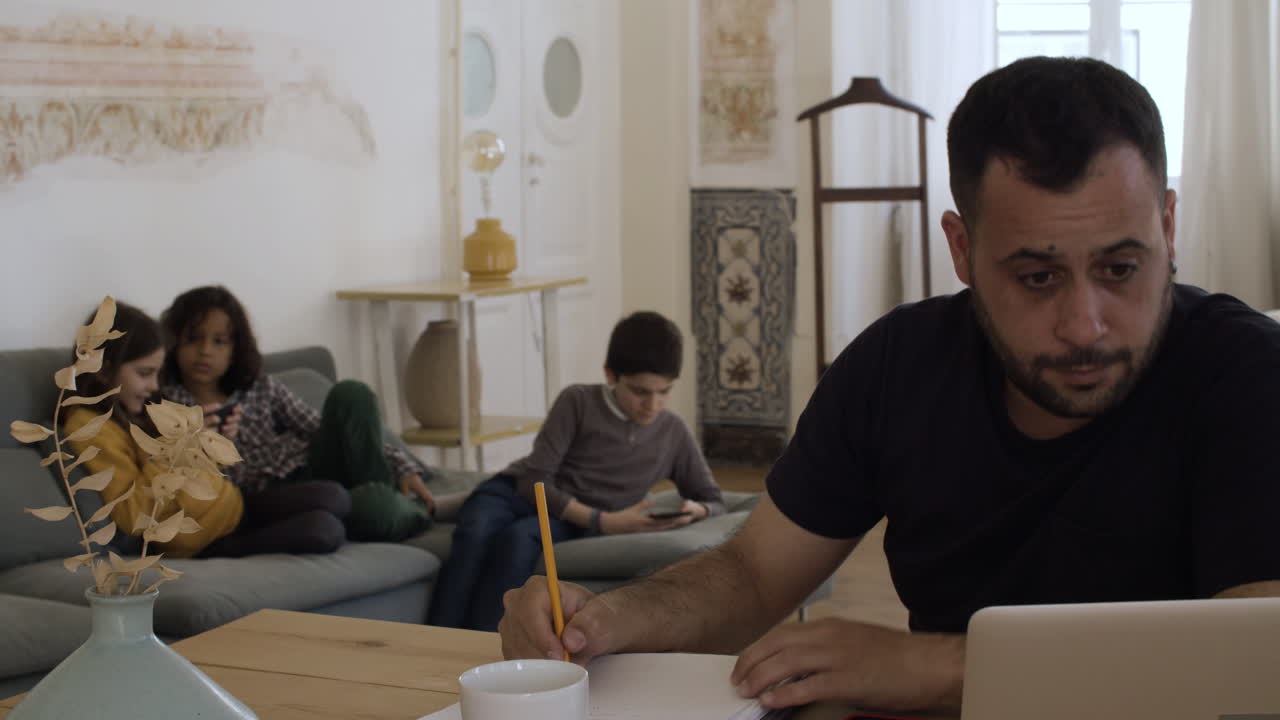 занятый бородатый отец, усердно работающий из дома.