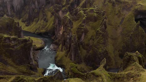 aerial 4k view of fjadragljufur glacier river canyon in iceland, europe, drone flying into a canyon