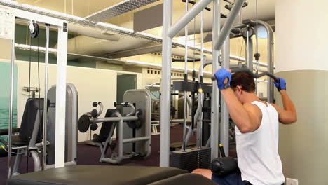 Fit-man-exercising-his-arms-on-weight-machine