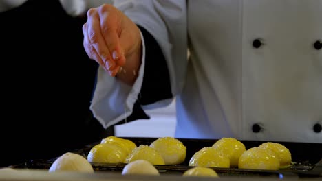 chef rociando azúcar en la bola de masa en la cocina 4k