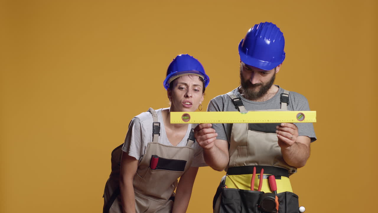 Construction workers using water level tools to measure flat surface