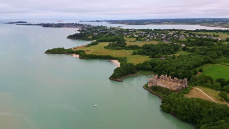 historic ruins of château du guildo castle at mouth of arguenon river, brittany coastline, saint-jacut-de-la-mer, france. aerial drone orbiting