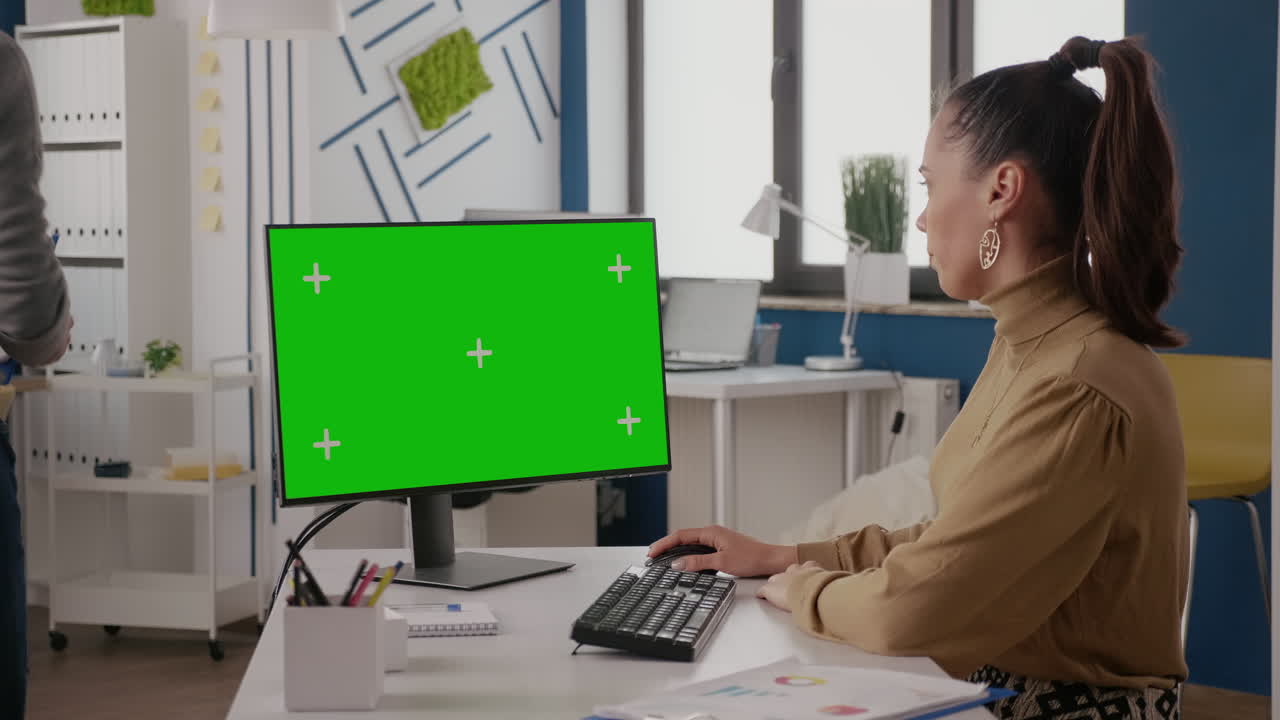 Close up of workmates talking and using green screen on monitor