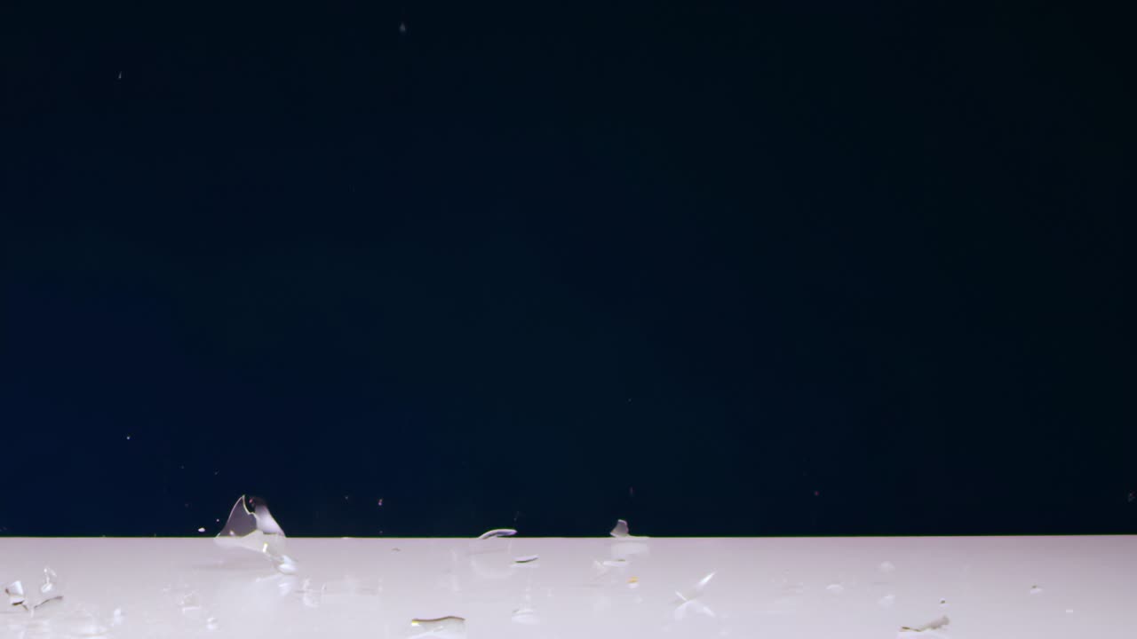 아만 (aman) 의 손은 테이블 위에 놓인 불빛 전구를 철 망치로 는다.