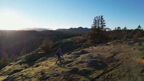 aerial of a male hiker on a rock bluff trail on vancouver island, canada, lone tree hill