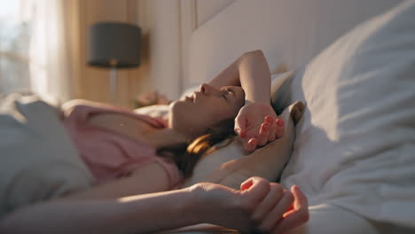 아침 일찍 알람 시계를 끄는 여자. 불행한 소녀가 다시 잠들고