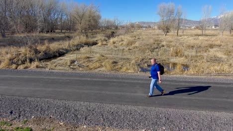 senior man out for a nature walk but still checks his smartphone for messages - aerial view