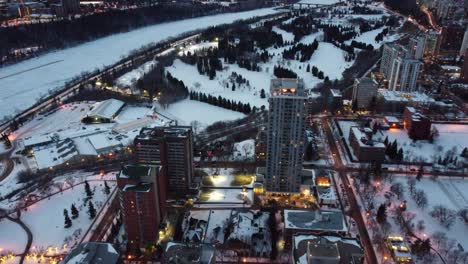 1-2 vista aérea de pájaro flydown noche sobre invierno futurista moderno residencial ríos borde edificios altos por campo de golf club de tenis cubierto esquí de fondo raquetas de nieve elegante universidad de lujo