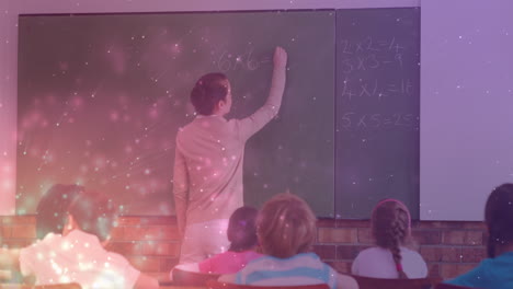 animation of light spots over caucasian female teacher writing on board with diverse schoolchildren