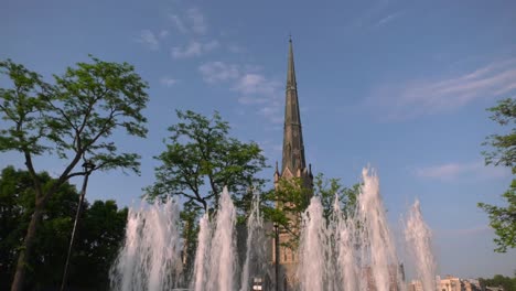 Water-fountain-in-summer-with-church-steeple-in-background