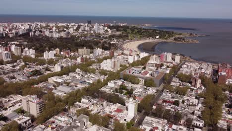 Toma-Panorámica-Aérea-De-La-Ciudad-De-Montevideo-Con-Playa-De-Arena-Y-Océano-Durante-El-Día-Soleado,-Uruguay