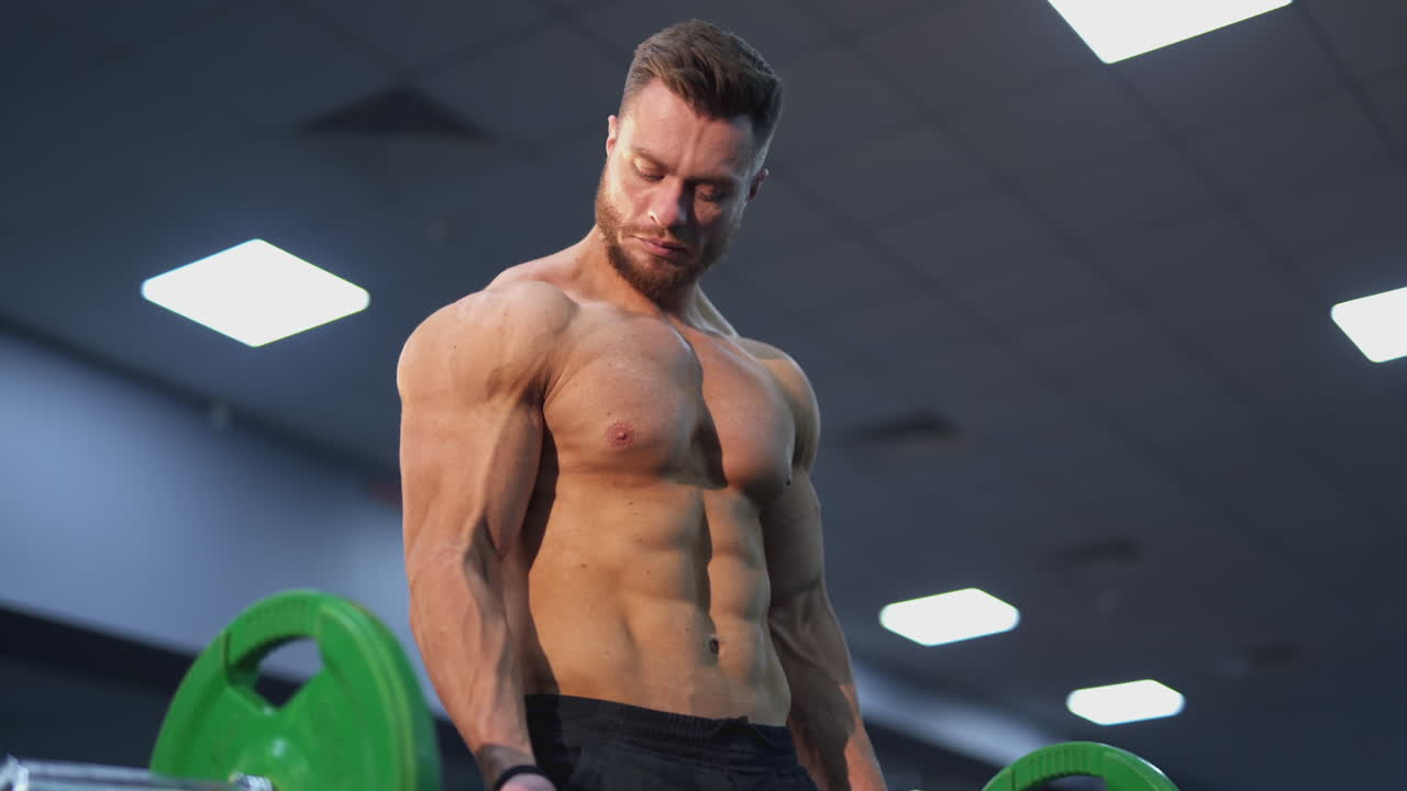 Athlete lifts a barbell. Power athletic man training his body with a heavy barbell. Strong muscular man doing workout. Close-up.