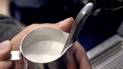 barista steaming milk with espresso machine for latte or cappuccino