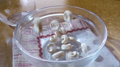 copos de avena crujientes en un tazón para un delicioso desayuno matutino con leche. cámara lenta con toma de seguimiento de rotación.