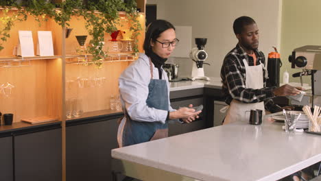 two multiethnic waiters working in a coffee shop 3