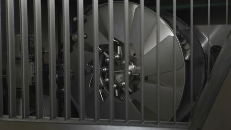 industrial fan blades behind a protective grille