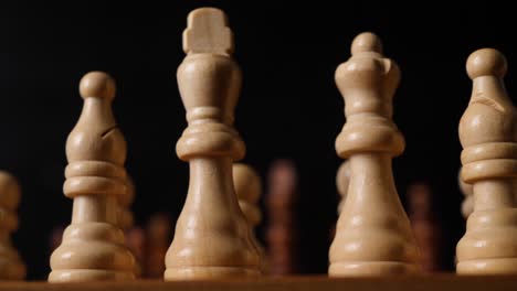 Close-up-slid-to-the-king-figures-on-a-chess-board,-isolated-black-background