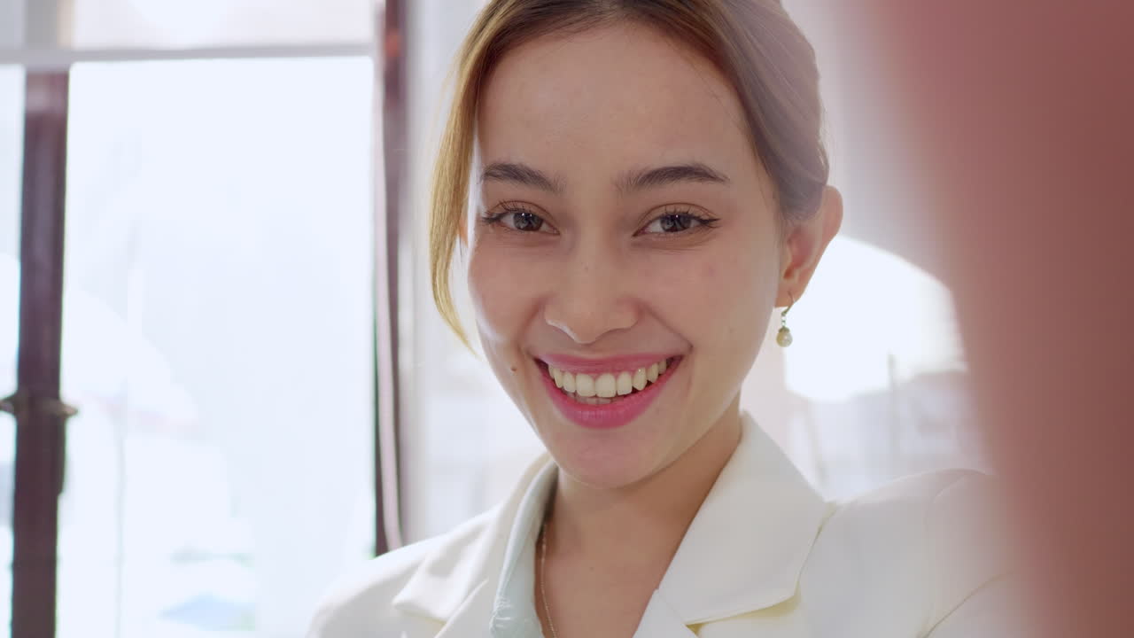 A cheerful young woman captures a moment in her office radiating positivity and professionalism.