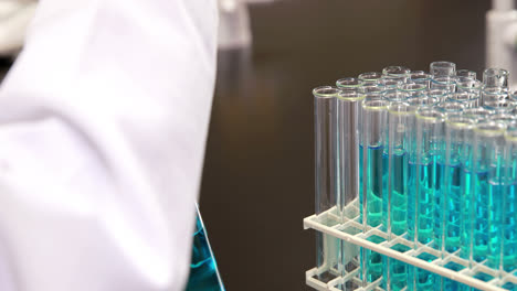 joven científico usando pipeta para poner químico en el tubo de ensayo