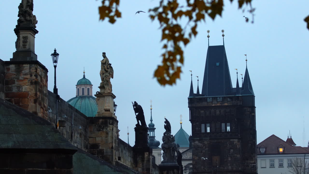 Powder Tower and Baroque statues of saints and religious figures on the medieval Charles bridge in Prague, Czech Republic
