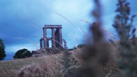 Monumento-Nacional-De-Escocia-En-Calton-Hill-Crepúsculo-Hierba-Primer-Plano-Plano-Cinematográfico