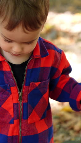 striped cloth wearing kid playing. small stylish boy outdoor walking. vertical video