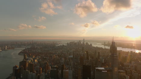 Forwards-fly-above-city-at-sunset.-Hazy-panoramic-view-of-cityscape-against-colourful-sky.-Manhattan,-New-York-City,-USA