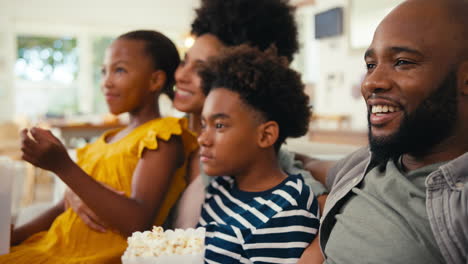 Familie-Isst-Popcorn-Zu-Hause,-Sitzt-Zusammen-Auf-Dem-Sofa-Und-Streamt-Show-Oder-Film-Auf-Den-Fernseher