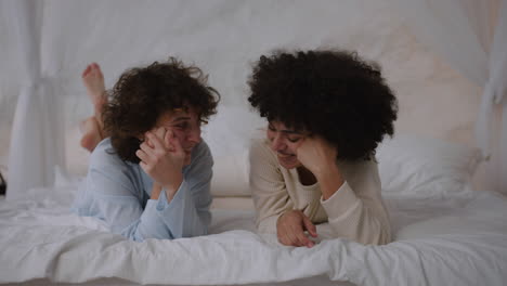 happy couple talking on bed