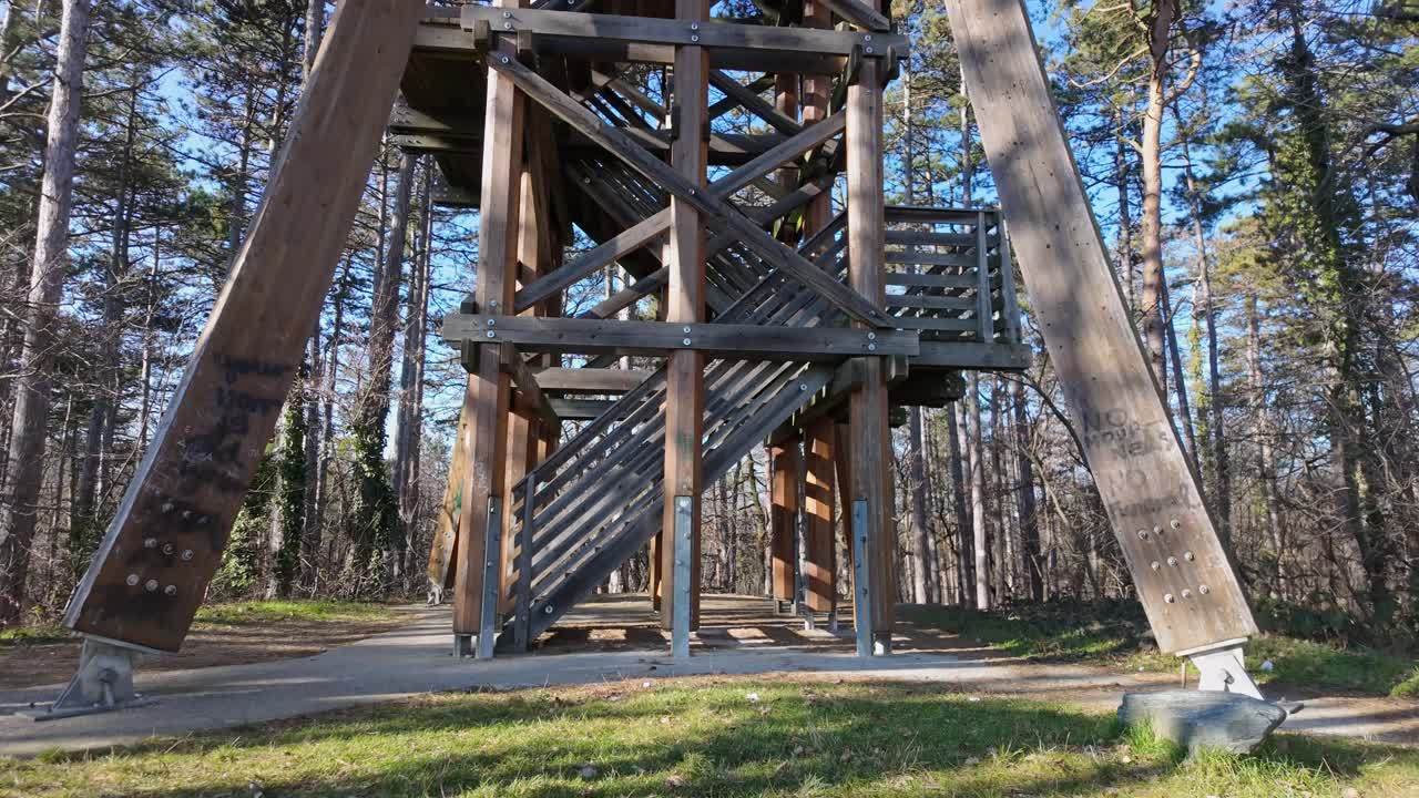 Tilt up shot of the wooden Sorhazdombi Lookout with the surrounding forest on a sunny day in Sopron, Hungary.