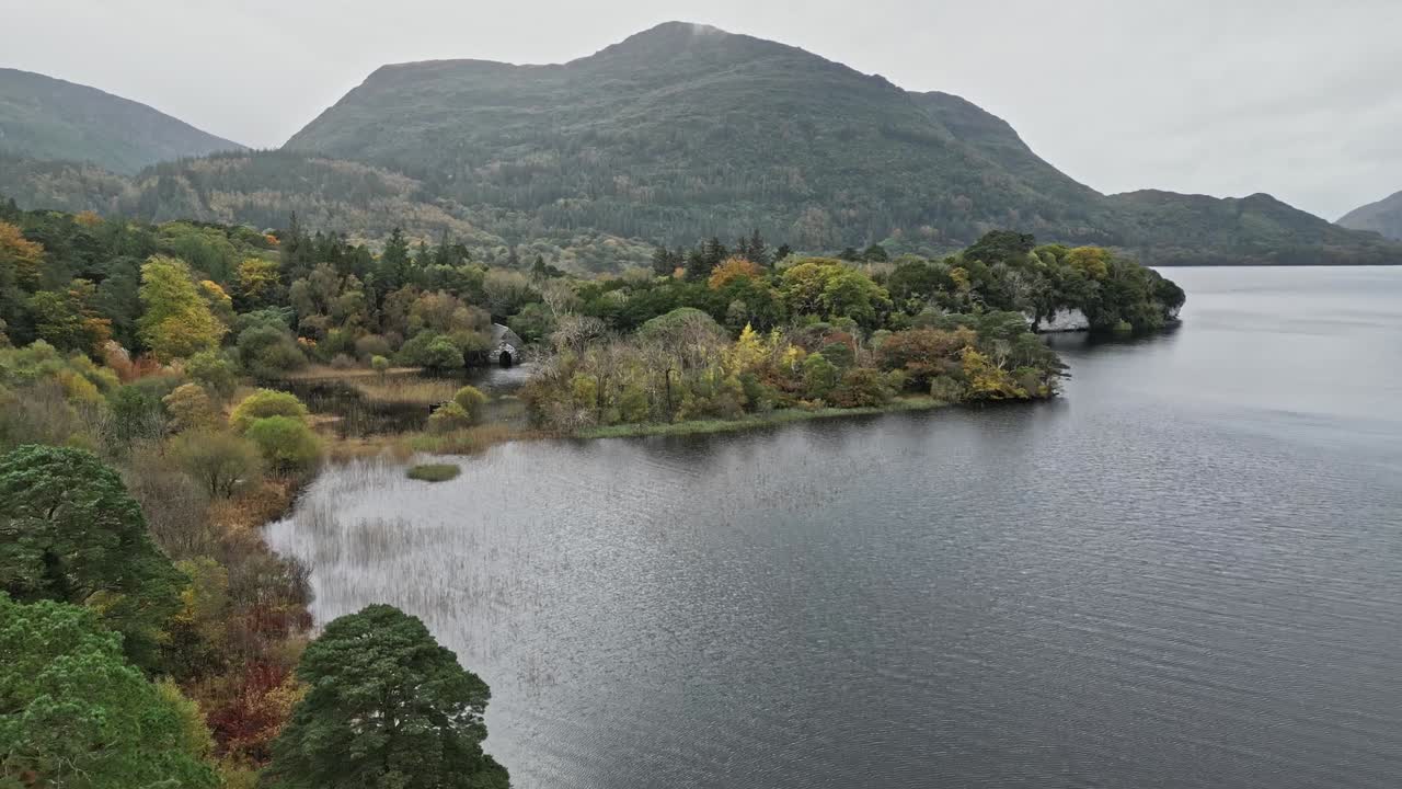 Serene view of Muckross House amidst tranquil lake and lush greenery