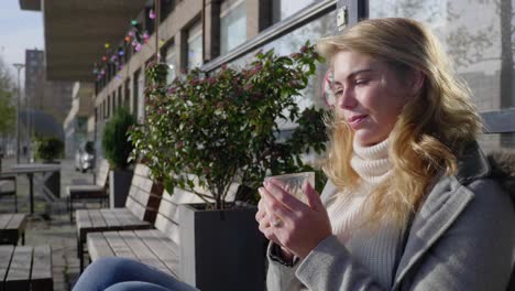 young adult woman relaxes in the morning sun with a cup of coffee