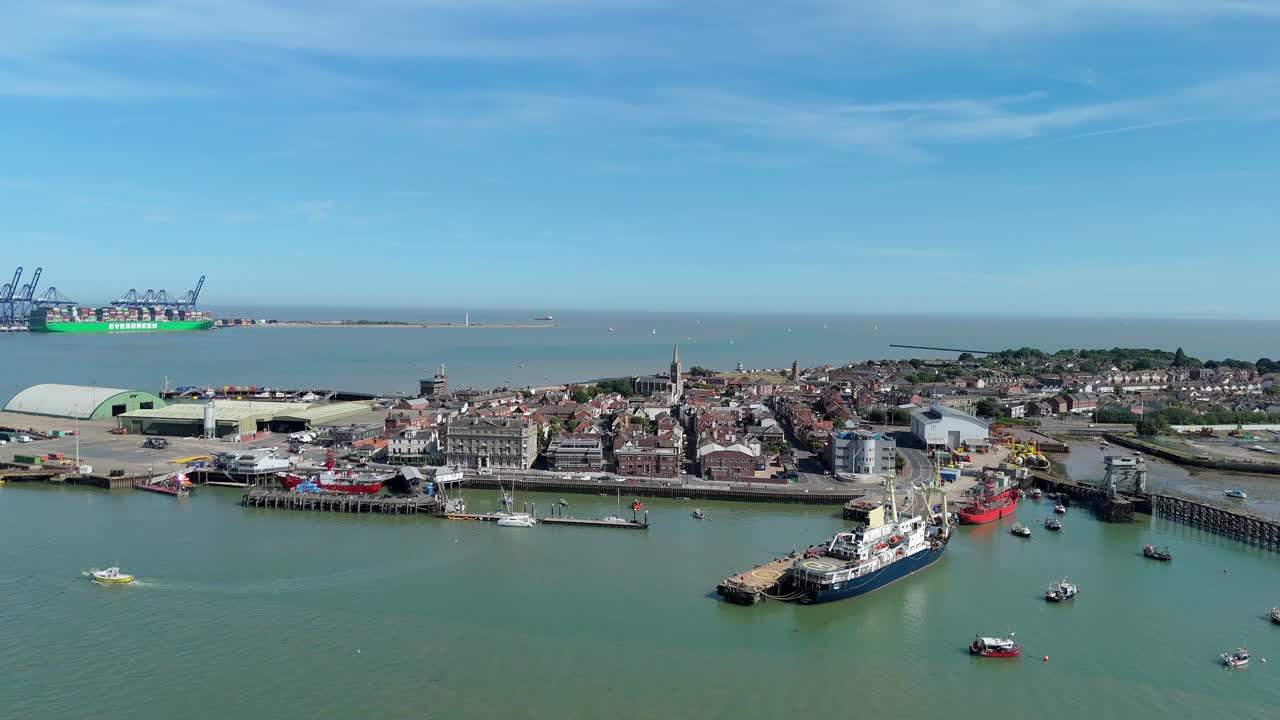 High angle drone shot of Harwich seaside town with cargo cranes and harbour infrastructure on sunny day along east coast of England