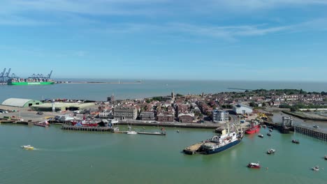 high angle drone shot of harwich seaside town with cargo cranes and harbour infrastructure on sunny day along east coast of england