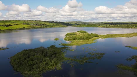 Eine-Luftaufnahme-Von-Grünen-Inseln-In-Der-Mitte-Des-Flusses-Lee-Bei-Flut-Und-Weißen-Wolken,-Die-Sich-Auf-Der-Blauen-Wasseroberfläche-Spiegeln