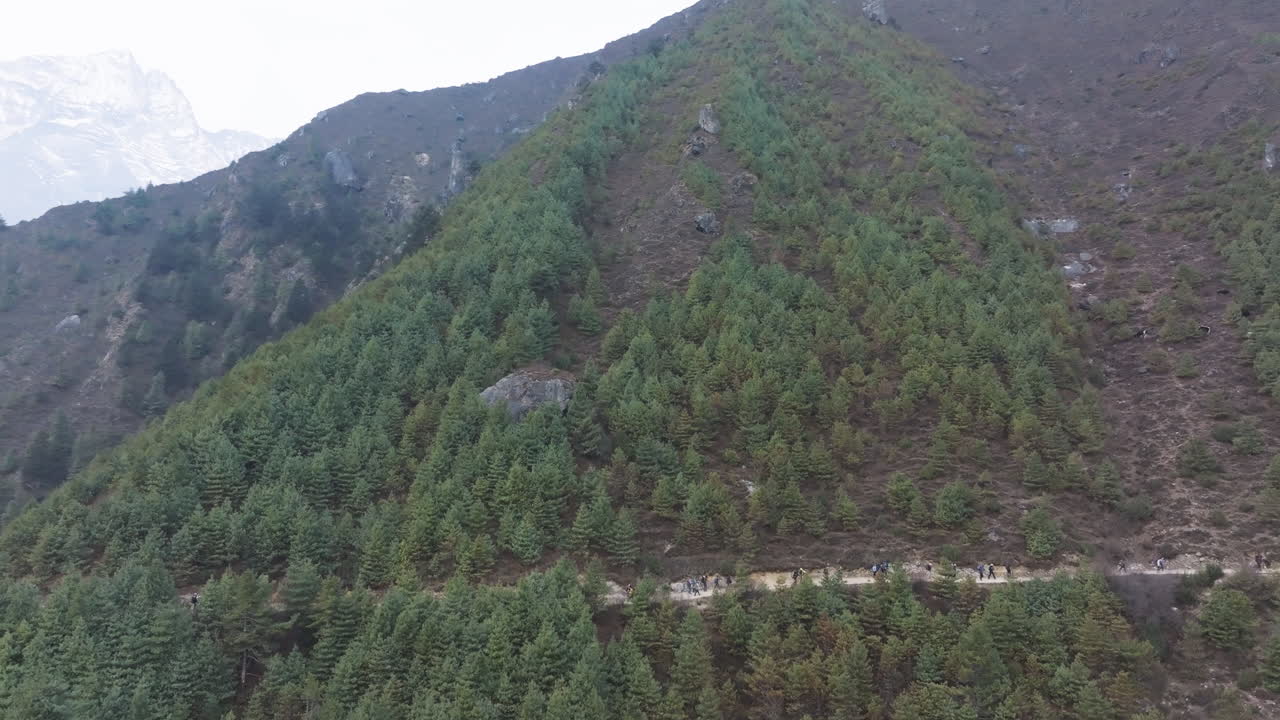Drone shot of Buddhist Stupa at Everest viewpoint Namche village, surrounded by forested hills promoting eco-tourism and sustainable travel in Nepal