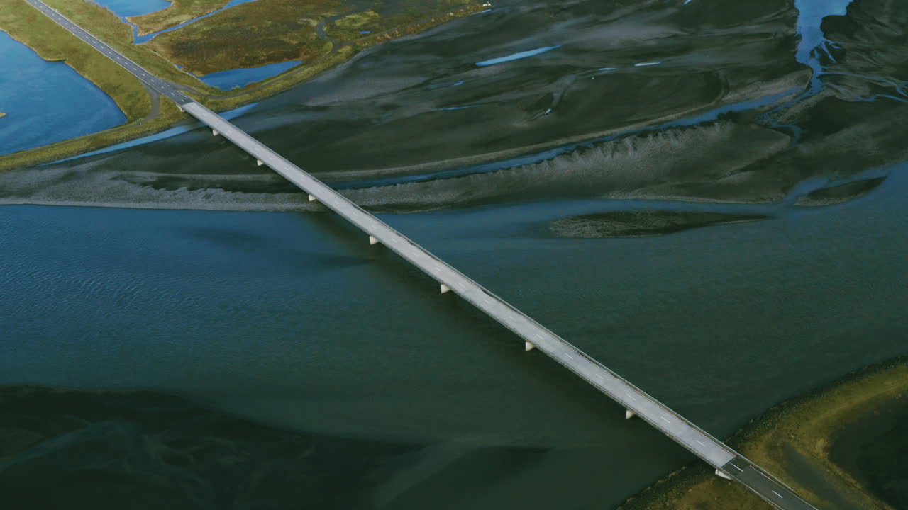 Drone shot over the top of an awesome bridge over glacial water. Top view of empty bridge over glacial meltwater, Icelandic delta. Lonley bridge.
