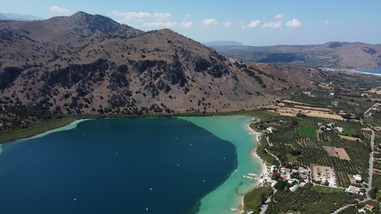 Kournas freshwater turquoise lake in Crete, Kournas mountainous village, Drone shot, Revealing shot