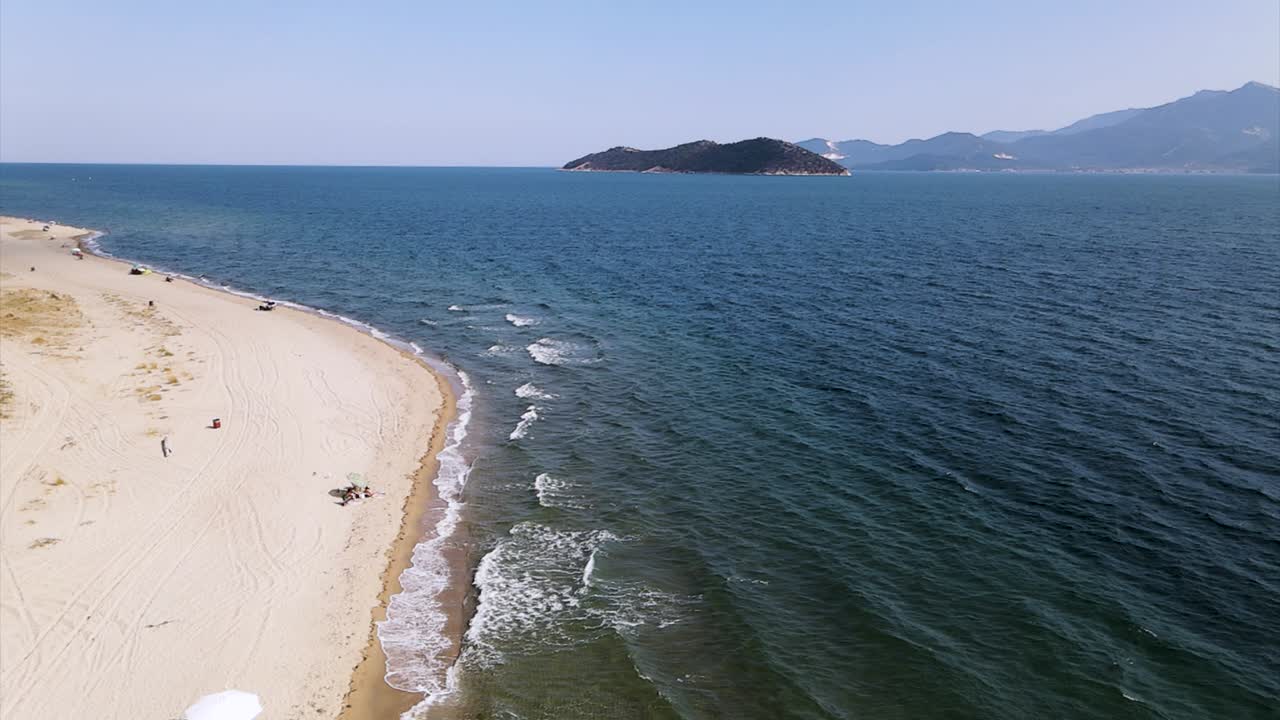 4k의 북부 그리스 카발라 케라모티 지역에 황금빛 모래가 있는 열대 해변 위의 슬로우 모션 공중 클립