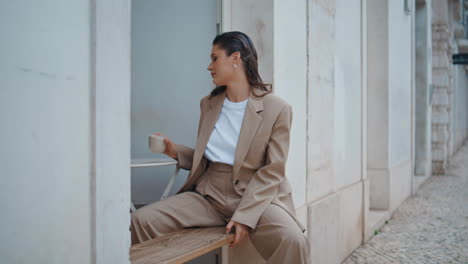 lady taking coffee cup relaxing alone at cafeteria terrace. happy businesswoman